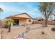 Well-maintained backyard featuring desert landscaping, covered patio, and unique rock detail at 15835 W Woodlands Ave, Goodyear, AZ 85338