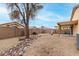 Spacious backyard featuring rock detail, desert landscaping, and an inviting covered patio at 15835 W Woodlands Ave, Goodyear, AZ 85338