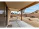 Inviting backyard patio with an open patio, gravel landscaping, and a unique rock feature at 15835 W Woodlands Ave, Goodyear, AZ 85338