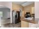 Traditional kitchen with stainless steel refrigerator, neutral countertops, and light wood cabinets at 15835 W Woodlands Ave, Goodyear, AZ 85338