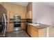 Functional kitchen with wooden cabinets, stainless steel appliances, and ample counter space at 15835 W Woodlands Ave, Goodyear, AZ 85338