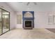 Open-concept living room with a cozy fireplace and sliding glass door at 15835 W Woodlands Ave, Goodyear, AZ 85338