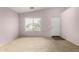 Bright living room featuring neutral carpet and an entry door at 15835 W Woodlands Ave, Goodyear, AZ 85338