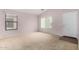 Light-filled living room with neutral carpet and multiple windows at 15835 W Woodlands Ave, Goodyear, AZ 85338