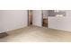 Spacious living area featuring neutral carpet, open layout, and kitchen access at 15835 W Woodlands Ave, Goodyear, AZ 85338