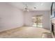 Bright living area featuring carpet, fireplace, and sliding glass door to backyard at 15835 W Woodlands Ave, Goodyear, AZ 85338