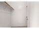 Walk-in closet with wooden rod and a glimpse of the door leading outside at 15835 W Woodlands Ave, Goodyear, AZ 85338