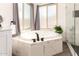 Corner bathtub, next to clear glass shower stall, has nice natural lighting at 16023 S 30Th Pl, Phoenix, AZ 85048