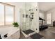 Modern bathroom featuring a glass-enclosed shower and a relaxing bathtub at 16023 S 30Th Pl, Phoenix, AZ 85048