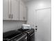 Laundry room with gray cabinetry, modern washer and dryer units, and a utility closet at 16023 S 30Th Pl, Phoenix, AZ 85048