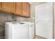 This laundry room features a washer and dryer as well as wooden cabinets for storage at 17616 N 20Th Dr, Phoenix, AZ 85023
