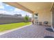 Covered patio and grassy backyard with brick-paved flooring and seating area at 1895 N 141St Ave, Goodyear, AZ 85395