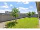 Landscaped backyard with a green lawn, young trees, and a brick wall border at 1895 N 141St Ave, Goodyear, AZ 85395