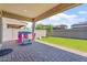 Covered patio and landscaped backyard with lawn, playhouse, and brick perimeter wall at 1895 N 141St Ave, Goodyear, AZ 85395