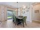 Open dining room with wood floors, stylish light fixture, and sliding doors to the backyard at 1895 N 141St Ave, Goodyear, AZ 85395