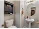 This powder room has a pedestal sink, cabinet storage, neutral walls, and a round mirror at 20440 N 39Th Dr, Glendale, AZ 85308
