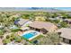 Aerial view featuring a pool, spa, covered patio, and well manicured landscaping in the backyard at 20585 W Garden St, Buckeye, AZ 85396