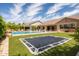 Lush backyard featuring an inground trampoline, sparkling pool, covered patio, and well-maintained landscaping at 20585 W Garden St, Buckeye, AZ 85396