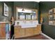 Elegant bathroom with a double vanity, farmhouse sink, and wood floors, offering a luxurious and comfortable experience at 20585 W Garden St, Buckeye, AZ 85396