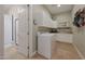 Well-lit laundry room featuring a washing machine, built-in cabinets, and tiled flooring at 20585 W Garden St, Buckeye, AZ 85396