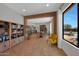 Open living area with a brick archway leading to the kitchen, seamlessly connects indoor and outdoor spaces with a pool view at 20585 W Garden St, Buckeye, AZ 85396