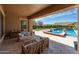 Inviting outdoor living space with comfortable seating, covered patio, and a sparkling pool with water features at 20585 W Garden St, Buckeye, AZ 85396