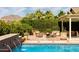 Relaxing poolside patio area includes lounge seating and a tranquil waterfall feature for outdoor enjoyment at 20585 W Garden St, Buckeye, AZ 85396