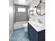 Updated bathroom with navy vanity and stylish tiling in shower and on floor at 2127 W San Miguel Ave, Phoenix, AZ 85015
