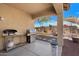 Spacious covered patio with a grill, overlooking the muraled backyard and desert landscaping at 2328 W Calle Marita --, Phoenix, AZ 85085
