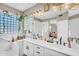 Elegant bathroom featuring double vanity, modern fixtures, and a window enclosed shower with decorative glass blocks at 2440 E Stephens Pl, Chandler, AZ 85225