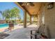 An inviting covered back patio features a ceiling fan, and a seating area overlooks the pristine pool at 2735 E Flower Ct, Gilbert, AZ 85298