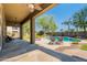 A covered back patio looks out onto a fenced yard with a sparkling blue pool and lounge chairs at 2735 E Flower Ct, Gilbert, AZ 85298