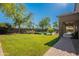 A beautifully landscaped backyard with a lush lawn, refreshing pool, and inviting covered patio creates a serene oasis at 2735 E Flower Ct, Gilbert, AZ 85298