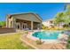 A beautiful backyard features a sparkling pool, covered patio, and well-manicured lawn perfect for entertaining at 2735 E Flower Ct, Gilbert, AZ 85298