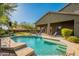 An inviting backyard showcases a sparkling pool, covered patio, and lush landscaping, ideal for relaxation and recreation at 2735 E Flower Ct, Gilbert, AZ 85298