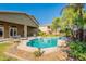 A spacious backyard featuring a pristine pool, lush greenery, and an inviting covered patio area at 2735 E Flower Ct, Gilbert, AZ 85298