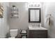 Cozy bathroom with a vanity, mirror, decorative shelving, and a toilet at 2735 E Flower Ct, Gilbert, AZ 85298