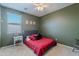 A bedroom with a window, ceiling fan, and neutral carpet that blends well with the olive-colored walls at 2735 E Flower Ct, Gilbert, AZ 85298