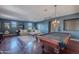 Spacious game room features a pool table, sectional, hardwood floors, recessed lighting and dark blue walls at 2735 E Flower Ct, Gilbert, AZ 85298