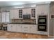 A modern kitchen boasting white cabinets, a gas cooktop, and stainless steel double ovens at 2735 E Flower Ct, Gilbert, AZ 85298