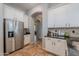 Bright kitchen with stainless steel refrigerator, granite counters and white cabinets at 2735 E Flower Ct, Gilbert, AZ 85298