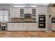 A well-equipped kitchen with stone backsplash, stainless steel oven, and sleek white cabinets at 2735 E Flower Ct, Gilbert, AZ 85298