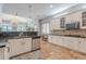 Stylish kitchen with white cabinetry, dark granite countertops, stone backsplash and flooring, with views of the living room at 2735 E Flower Ct, Gilbert, AZ 85298