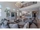 Spacious living room with a grand chandelier, neutral decor, and view of the open-concept kitchen area at 2735 E Flower Ct, Gilbert, AZ 85298