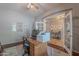 Functional home office with a wooden desk, tile floors, and an open doorway to the brightly lit dining area at 2735 E Flower Ct, Gilbert, AZ 85298