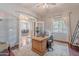 Bright office space with warm lighting, wooden desk, open French doors to dining room and tile flooring throughout at 2735 E Flower Ct, Gilbert, AZ 85298