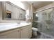 Well-lit bathroom with framed mirror, white vanity, and walk-in glass shower at 30248 W Earll Dr, Buckeye, AZ 85396