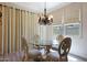 Elegant dining room featuring a chandelier, ornate chairs, and natural light at 30248 W Earll Dr, Buckeye, AZ 85396
