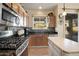 Open-concept kitchen features a gas range, island, and stainless-steel appliances at 30248 W Earll Dr, Buckeye, AZ 85396