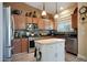 Well-lit kitchen with stainless steel appliances, granite countertops, and a white center island at 30248 W Earll Dr, Buckeye, AZ 85396